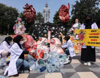 Aktivis lingkungan membentangkan poster saat aksi Plastic Free July 2025 di depan Gedung Negara Grahadi, Surabaya . Aksi damai yang menyerukan bahaya mikroplastik bagi kesehatan manusia itu dilakukan komunitas MARAPAIMA dan ECOTON dengan menyampaikan seju