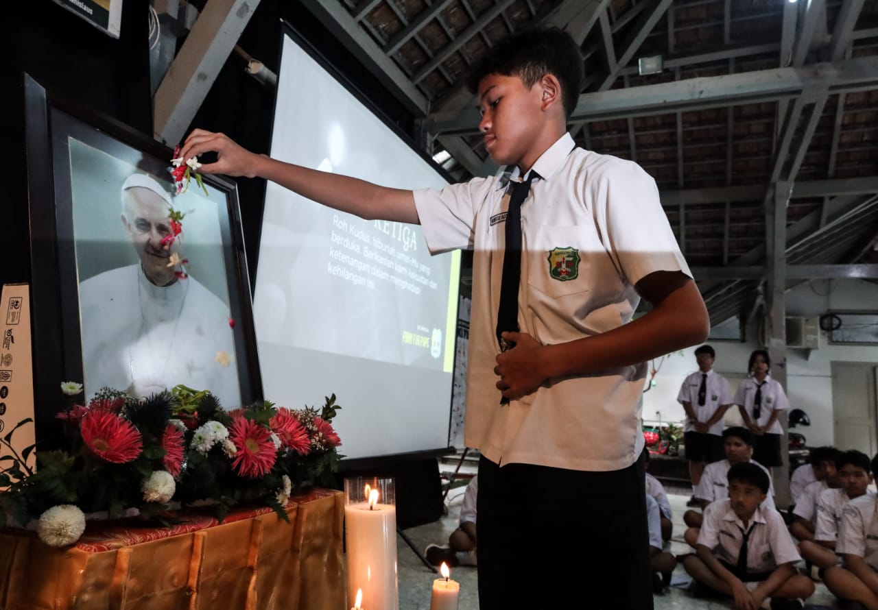 Siswa dan tenaga pengajar menunaikan doa dan tabur bunga untuk menghormati Paus Fransiskus. Foto/Robertus Rizky.