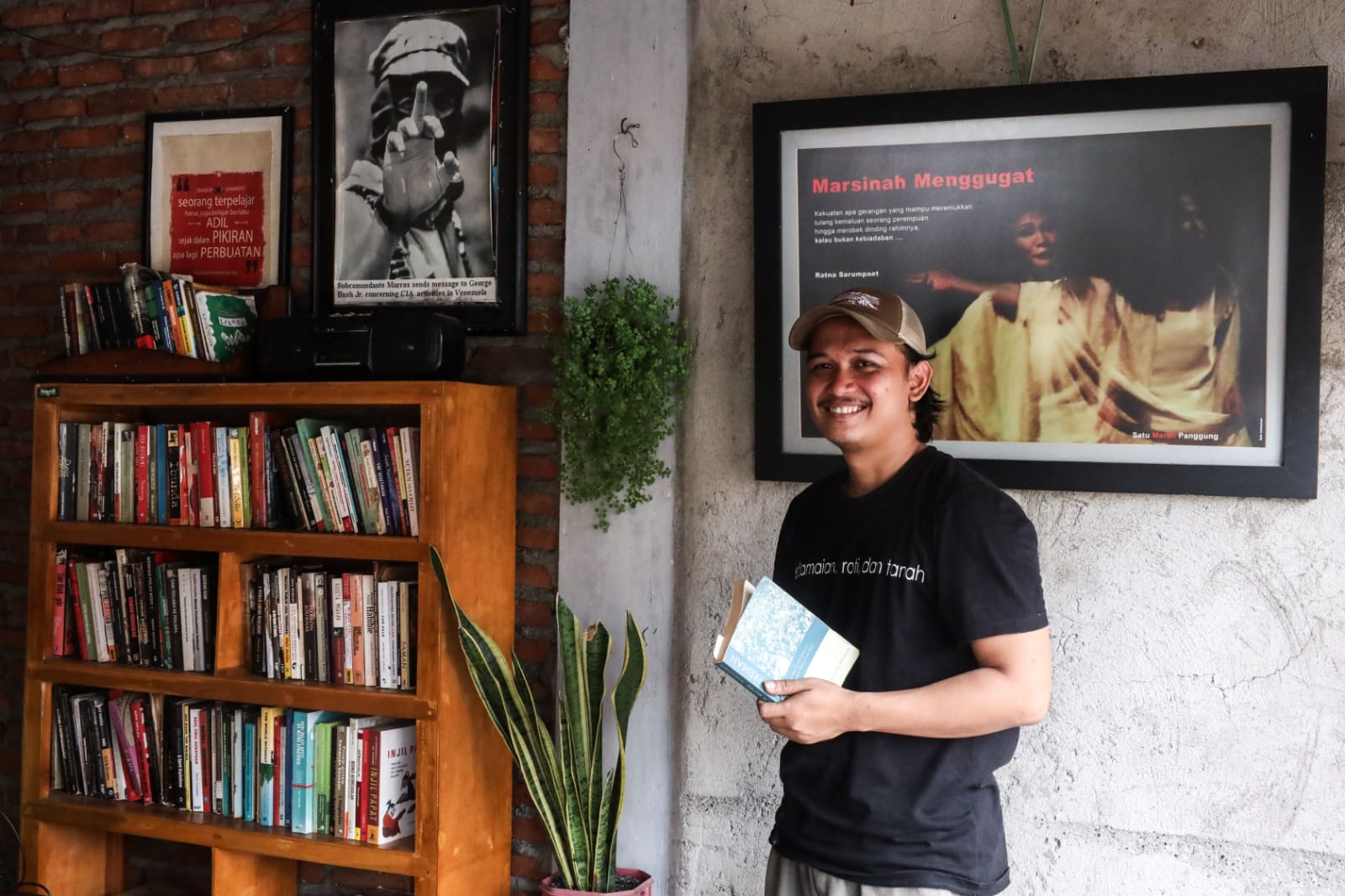 Darius Tris Sutrisno, Pemilik Warkop Samiroto, berdiri di depan perpustakaan kecil di warkopnya. (Foto : Robertus Risky)