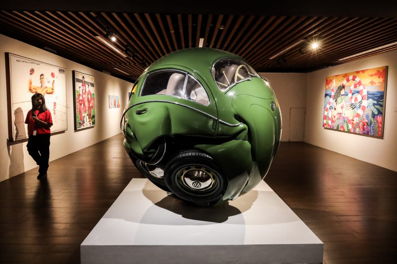 Menikmati setiap detail karya di Artsub 2025—di tengah sorot lampu dan riuh percakapan, seni berbicara dengan caranya sendiri di Balai Pemuda, Surabaya. (Sumber Foto: Robertus Riski)