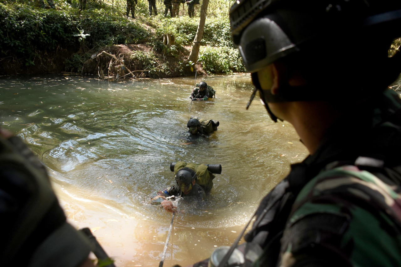 Prajurit Brigif 2 Marinir menyeberangi sungai dengan penuh kewaspadaan dalam latihan tempur di Puslatpurmar 4 Purboyo, Malang Selatan. 