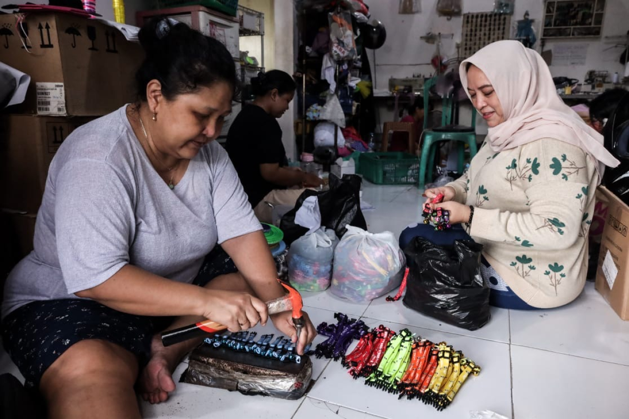 Di ruang kecil yang dipenuhi warna dan tumpukan kain, Dini Arianti bersama tim perajin di rumah produksinya, menenun rezeki dengan sabar.