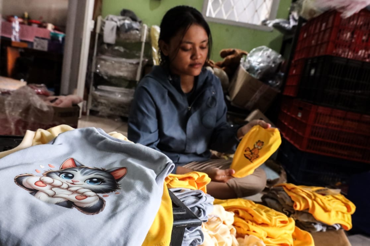Pekerja rumah Jahit Dini Ardianti yang menyiapkan baju anabul untuk siap kirim.