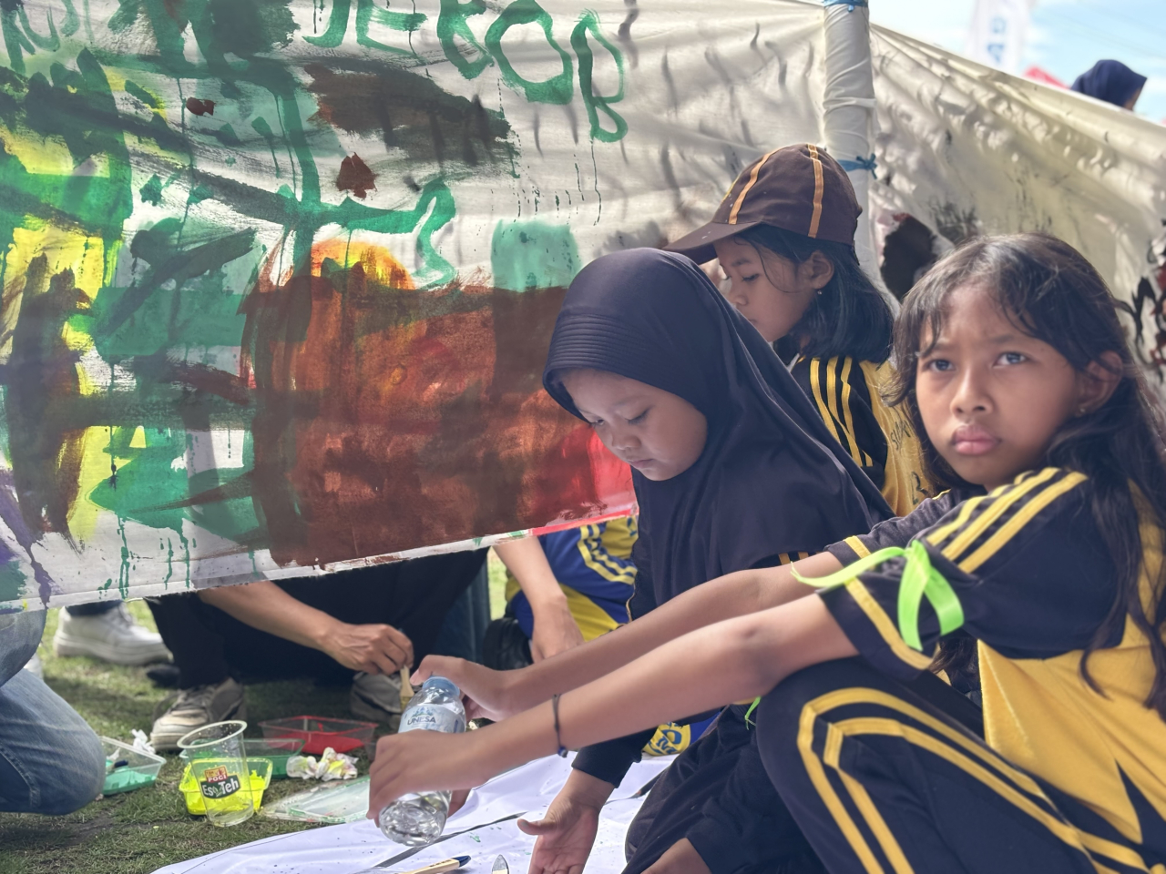 Warna-warna itu bukan sekadar cat. Ada yang menumpahkan gembira, ada yang menyembunyikan resah. Dari kuas kecil di tangan mereka, kita belajar: anak-anak punya cara sendiri untuk bercerita—tanpa kata, tapi jujur sekali. (Sumber Foto: Atap)