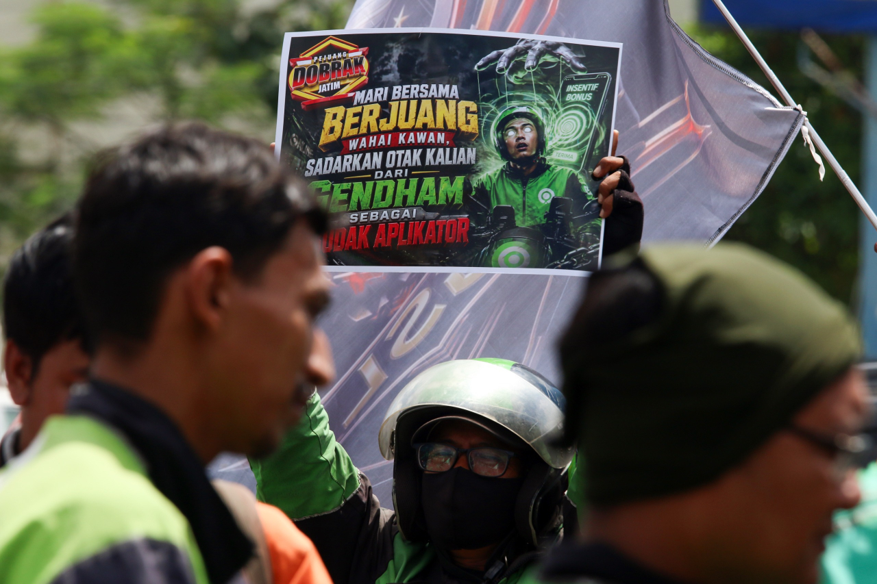 Seorang driver online mengangkat poster tuntutan saat aksi DOBRAK di Surabaya, Selasa (28/4/2026). Seorang driver online mengangkat poster tuntutan saat aksi DOBRAK di Surabaya, Selasa (28/4/2026). (Foto: M. Iffan)